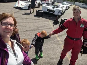 Chris in his racing suit with his family at the track