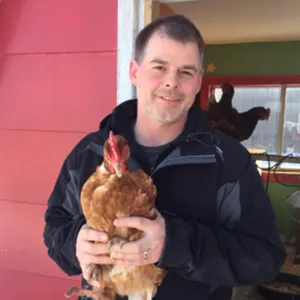 Chris Saunders holding a chicken